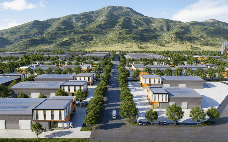 A solar-powered residential neighborhood with rows of modern houses, tree-lined streets, and mountains in the background.